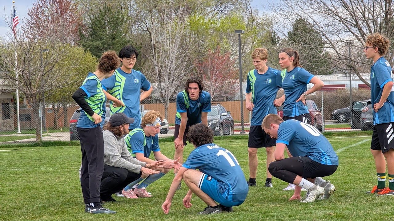 A youth player listening to instruction from teammates on the sideline.